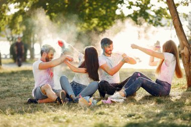 People have fun in a park with holi paints