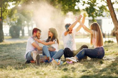 People have fun in a park with holi paints