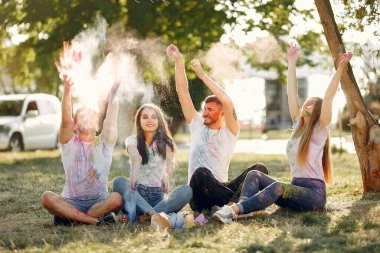 People have fun in a park with holi paints