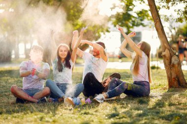 People have fun in a park with holi paints