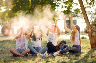 People have fun in a park with holi paints