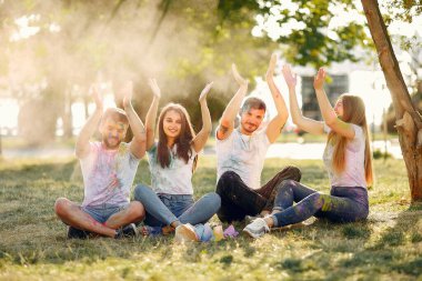 People have fun in a park with holi paints