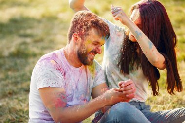 People have fun in a park with holi paints