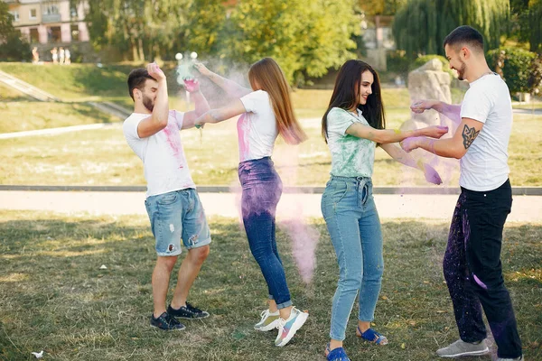 People have fun in a park with holi paints