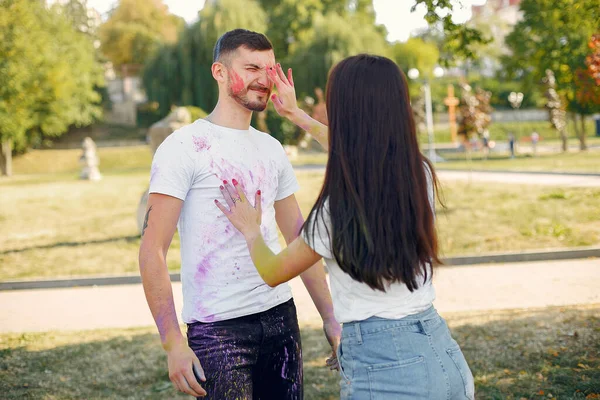 People have fun in a park with holi paints