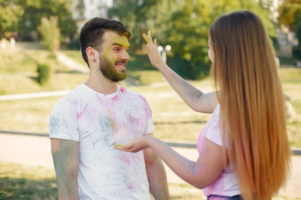 People have fun in a park with holi paints