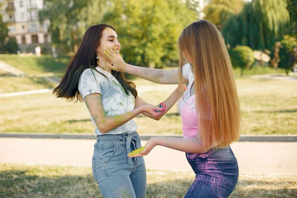 Two girls have fun in a park with holi paints — 图库照片