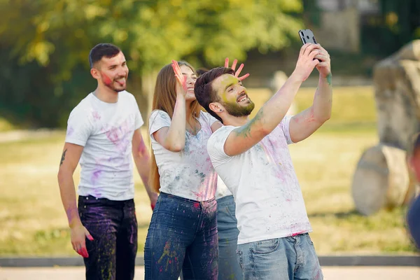 People have fun in a park with holi paints