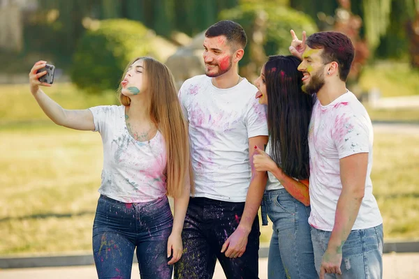 People have fun in a park with holi paints