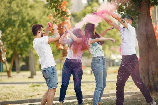 People have fun in a park with holi paints