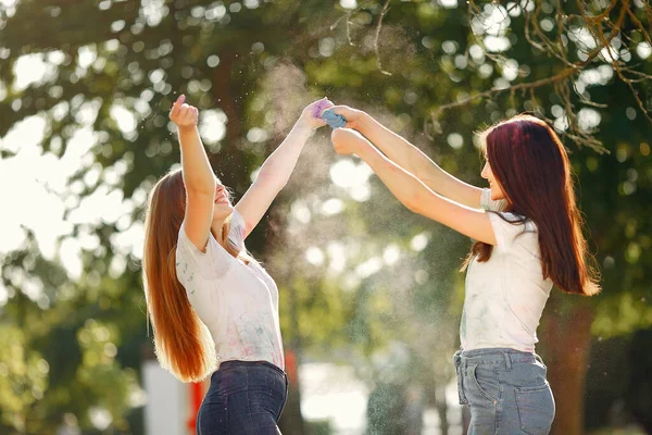 Two girls have fun in a park with holi paints — 图库照片