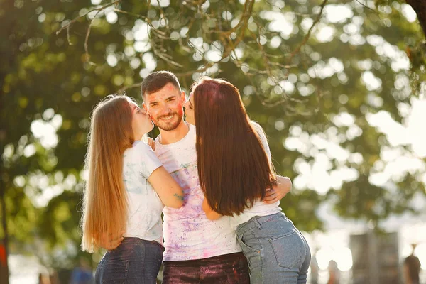 People have fun in a park with holi paints