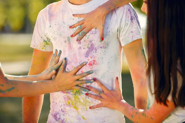 People have fun in a park with holi paints