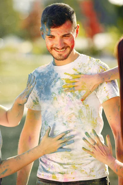 People have fun in a park with holi paints