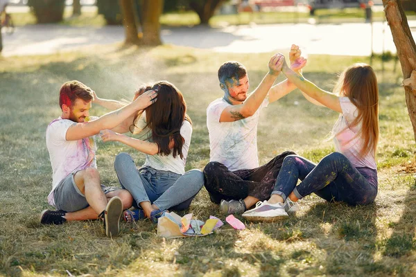 People have fun in a park with holi paints