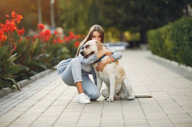 Kız tatlı bir köpekle bahar yoğunluğunda yürüyor.