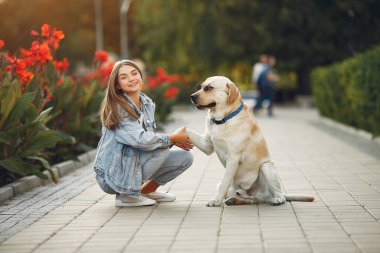 Kız tatlı bir köpekle bahar yoğunluğunda yürüyor.