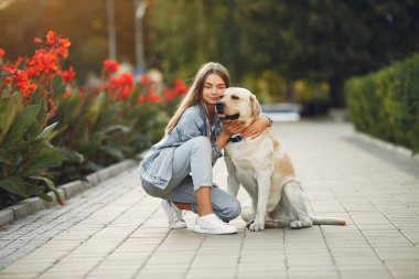 Kız tatlı bir köpekle bahar yoğunluğunda yürüyor.