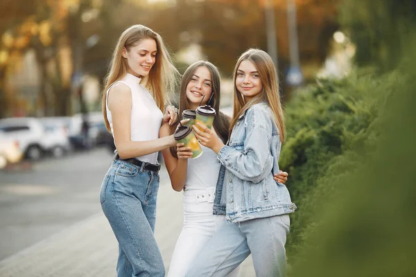 Chicas caminando en una universidad de primavera y sosteniendo el café en su mano —  Fotos de Stock