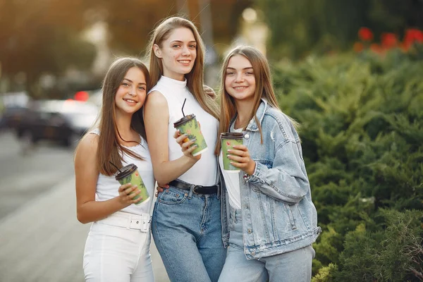 Девушки, идущие весной и держащие кофе в руке — стоковое фото