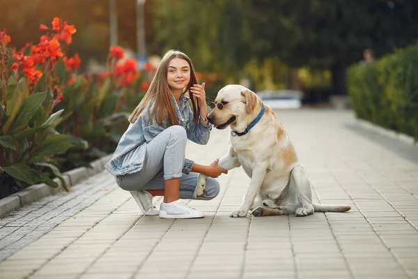 Menina andando em uma primavera sity com cão bonito — Fotografia de Stock