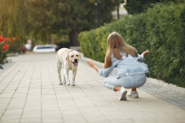 Kız tatlı bir köpekle bahar yoğunluğunda yürüyor.