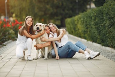Bahar mevsiminde tatlı bir köpekle oturan kızlar