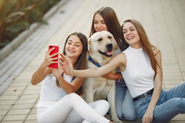 Bahar mevsiminde tatlı bir köpekle oturan kızlar