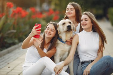 Bahar mevsiminde tatlı bir köpekle oturan kızlar