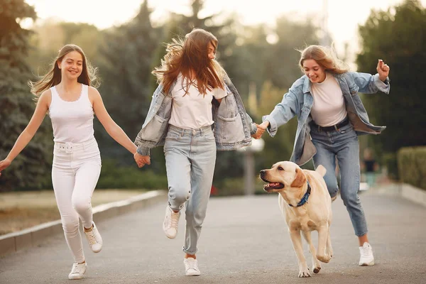 Ragazze che camminano in una città primaverile con cane carino — Foto Stock