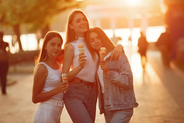 Girls walking in a spring sity and hold ice cream in hand — Stock Photo, Image