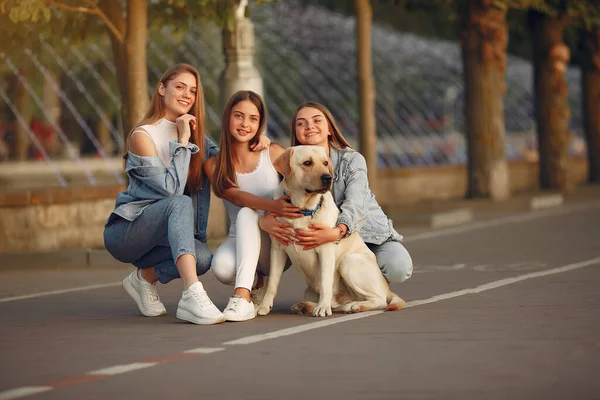 Meisjes wandelen in een lente sity met schattige hond — Stockfoto