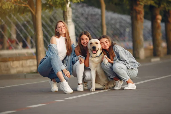 Flickor går i en vårvikt med söt hund — Stockfoto