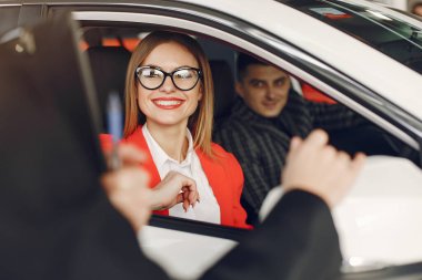 Bir araba galerisinde şık ve zarif insanlar.