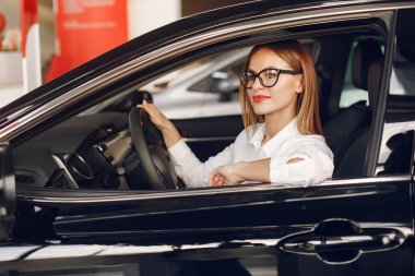 Bir araba galerisinde şık ve zarif bir kadın.