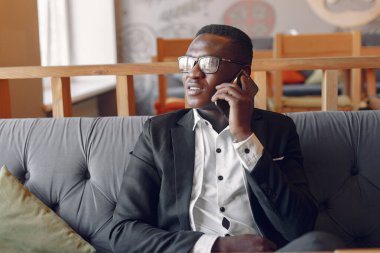 Kafede oturan siyah bir adam.