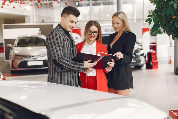 Stylish and elegant people in a car salon