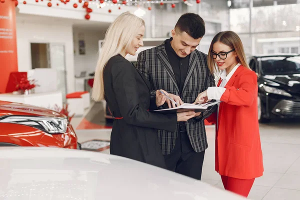 Stylish and elegant people in a car salon