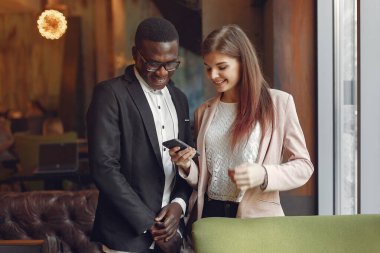 Uluslararası insanlar bir kafede durup kahve içiyorlar.