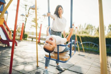 Anne ve küçük çocuk oyun parkında