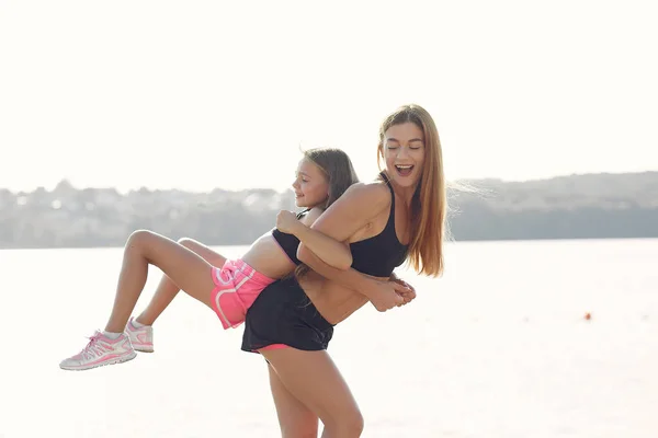 Moeder met dochter doet sport aan het water — Stockfoto