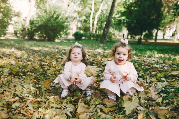 Cute little sisters plauing in a spring park — Stock Photo, Image