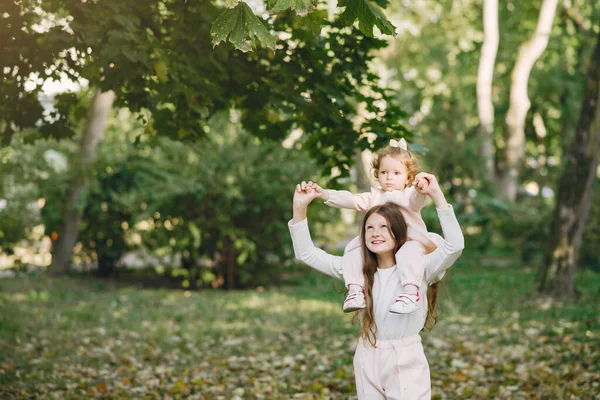 Söta småsystrar som plauderar i en vårpark — Stockfoto