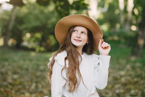 공원에서 갈색 모자를 쓴 채 공원에서 있는 어린 소녀 — 스톡 사진
