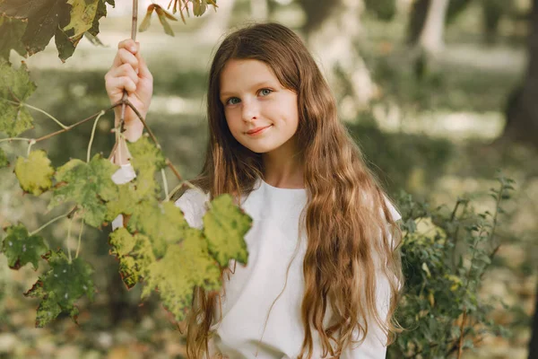 Petite fille dans un parc en chemisier blanc — Photo