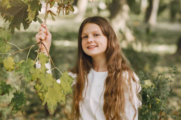 Little girl in a park in a white blouse — Stock Photo, Image