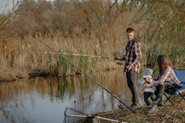 Famiglia seduta vicino al fiume in una pesca mattutina — Foto Stock