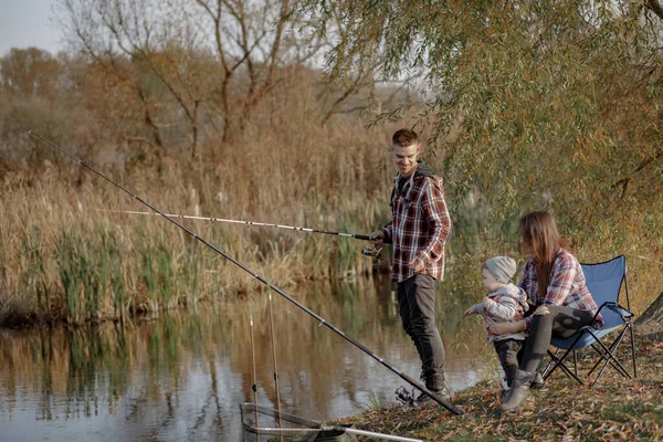 Famiglia seduta vicino al fiume in una pesca mattutina — Foto Stock