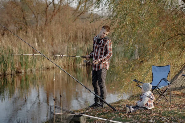 Padre con piccolo figlio vicino al fiume in una pesca mattutina — Foto Stock