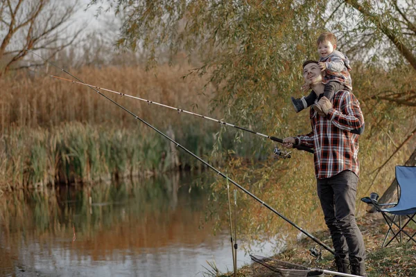 Ojciec z małym synkiem nad rzeką w porannym łowieniu ryb — Zdjęcie stockowe